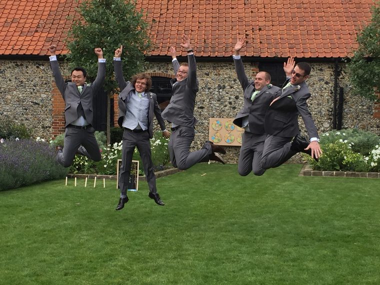Burst frame 1: five groomsmen crouched, about to jump